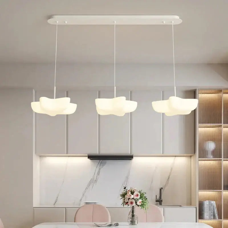 Three white cloud white floating pendant lights hang from a sleek fixture perfect for modern dining room decorbites pendant light