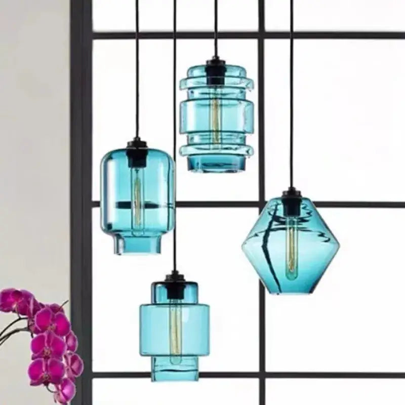 Set of four modern teal decorbites geometric glass pendant lights with stacked shapes and visible filament bulbs