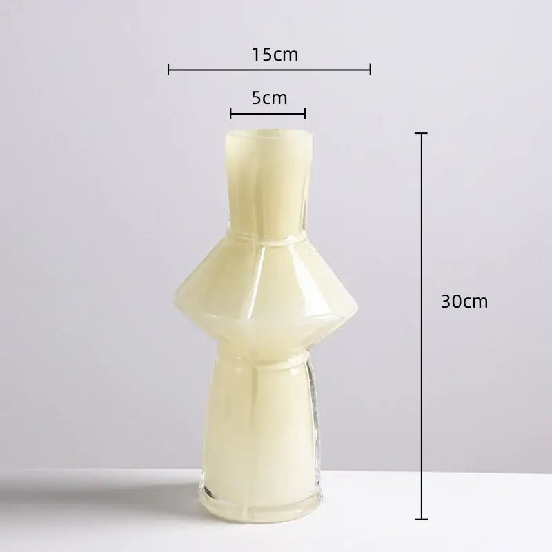 A translucent cream-colored glass vase with a flared neck and faceted design in the decorbites colorful geometric set