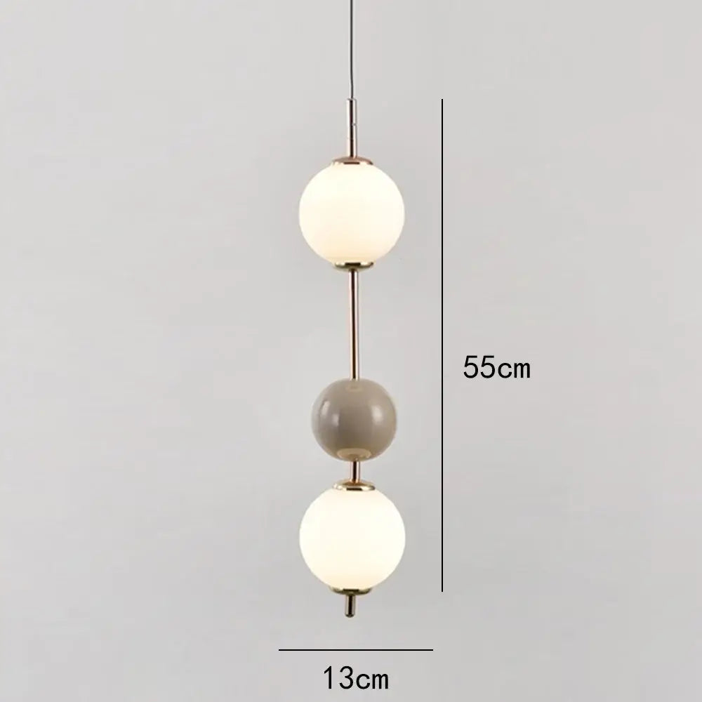 Modern pendant light with three spherical glass globes in frosted white and matte gray on a brass frame for dining room decorbites glass ball led
