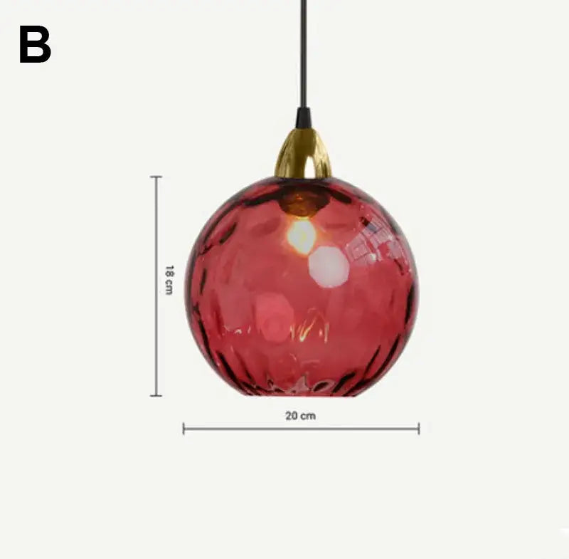 A spherical red decorbites glass ball pendant light with textured surface and gold-toned fixture for modern kitchens