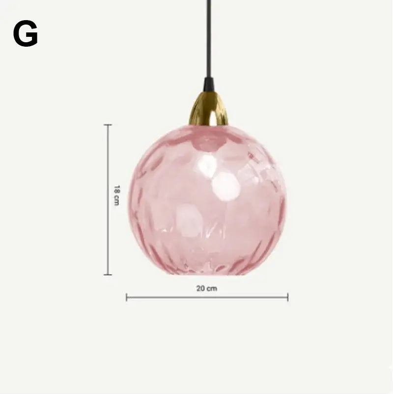 Delicate pink decorbites glass ball pendant light with faceted textured surface and gold-toned fixture for kitchens