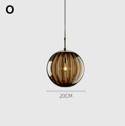 A sleek amber glass ball lustre pendant light with vertical ridges and visible filament bulb for modern kitchens