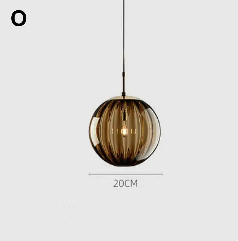 A sleek amber glass ball lustre pendant light with vertical ridges and visible filament bulb for modern kitchens