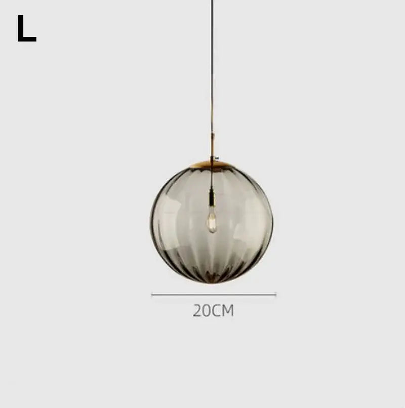 A sleek 20cm diameter modern pendant light with textured smoked glass ball and brass-toned decorbites glass ball lustre
