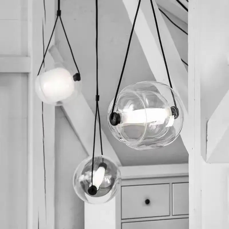 Modern colorful glass capsule led pendant light featuring clear glass globes with black cords and metal fixtures for kitchen bar