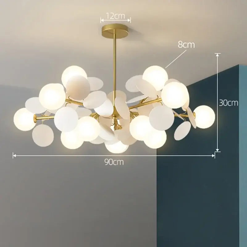 Gold-toned decorbites branch chandelier with frosted glass globe shades in a modern branching design for living room