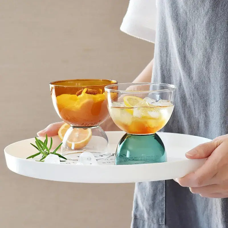 Two colorful glass dessert ice cream cups with stem bases in amber and teal for modern dining room use