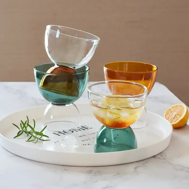 Set of four colorful modern glass dessert ice cream cups in transparent teal amber and orange hues with stemless design