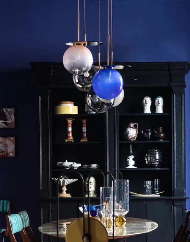 A modern colorful glass metal pendant lamp with gradient spherical globes suspended by thin rods for dining room decorbites colorful glass