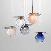 Modern colorful glass metal pendant lamp with spherical shades in clear, blush pink, frosted white, and gradient blue by decorbites
