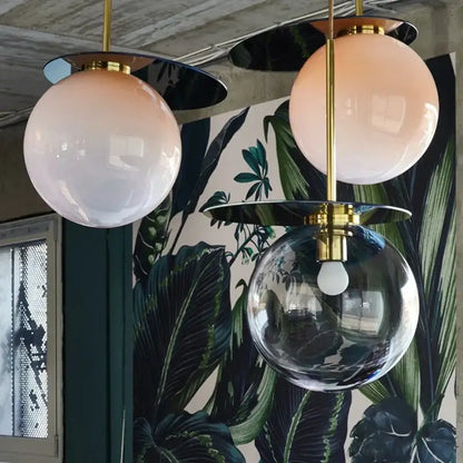 Three spherical pendant lights with brass fixtures and frosted pink and clear glass globes decorbites colorful glass metal lamp