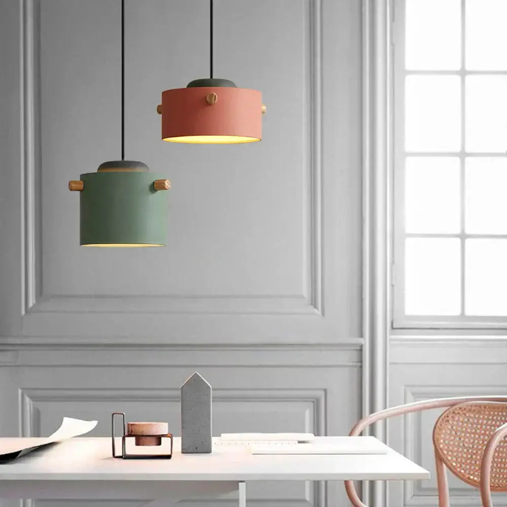 Two modern colorful led pendant lights with coral and sage matte bodies and gold-toned handles for dining room decorbites colorful led