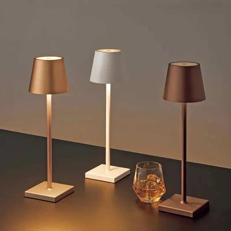 Three sleek modern decorbites crystal led rechargeable table lamps with cylindrical shades in gold white and bronze tones