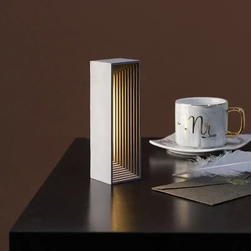 Modern concrete stone table lamp with white exterior and golden wood slats emitting warm light for bedroom decorbites concrete stone