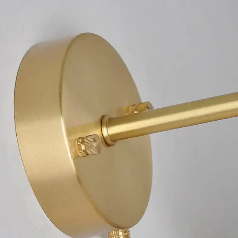 Modern copper and off-white ribbed wall light fixture with gold-finished brass circular base and slender arm for bedroom use