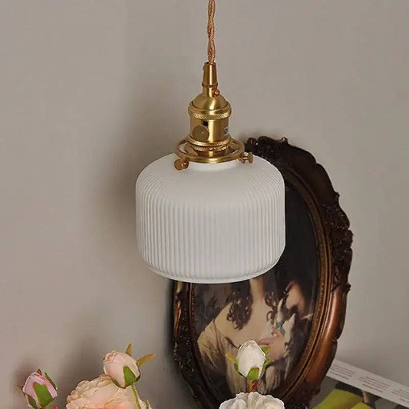 Modern white ribbed glass wall light fixture with brass-finished metal for bedroom sconce lighting