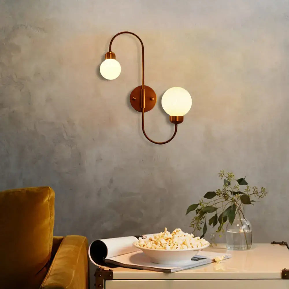 Modern copper living room spherical wall sconce with two curved arms and frosted white glass globe shades