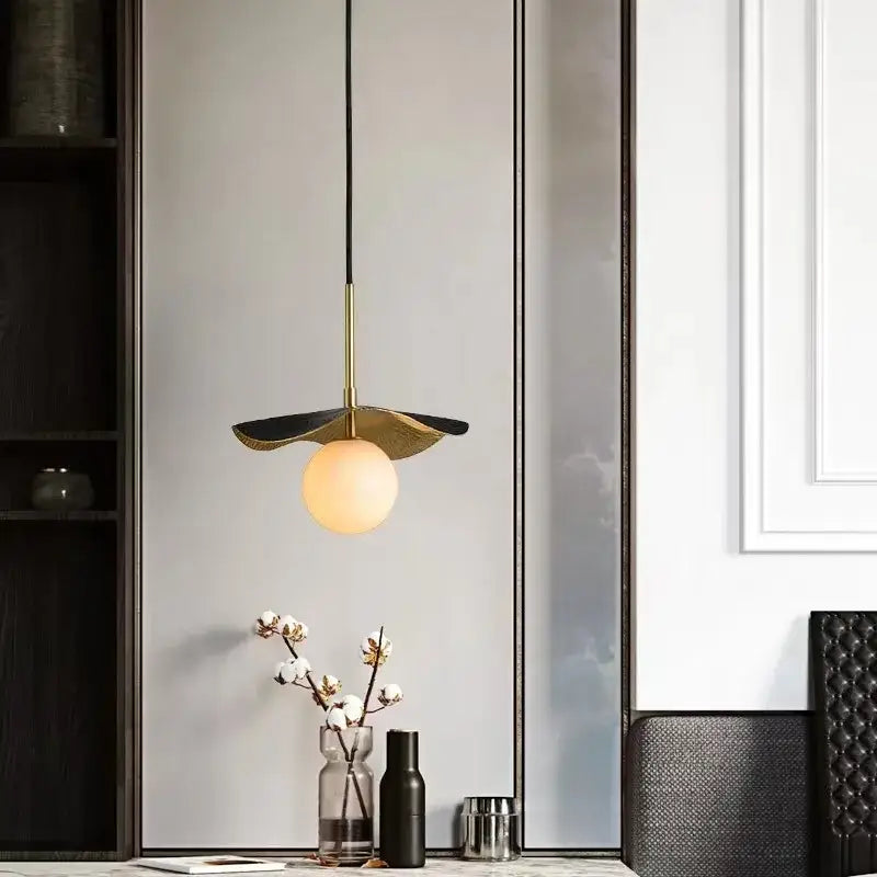 Modern decorbites copper bedside chandelier with gold-toned metal frame, black accents, and illuminated marble glass ball