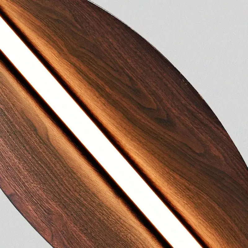 Modern copper brown metal leaf wall sconce with a dark brown wooden surfboard and glowing white led decorbites brown metal strip