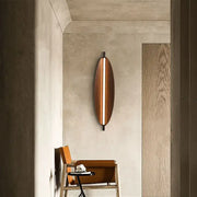 A sleek modern copper brown metal leaf wall sconce with elongated vertical light strip for bedroom decorbites brown metal