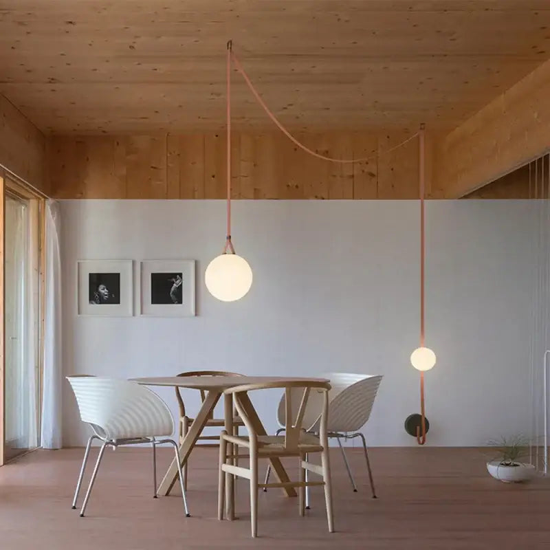 Modern copper decorbites glass ball pendant lamp with a frosted glass ball shade suspended by a copper cord for dining room