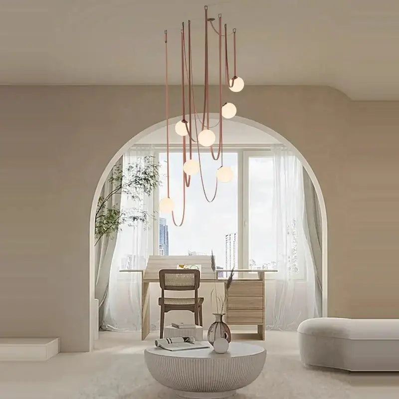 A modern copper decorbites glass ball pendant lamp with slender cords and white bulbs for dining room lighting