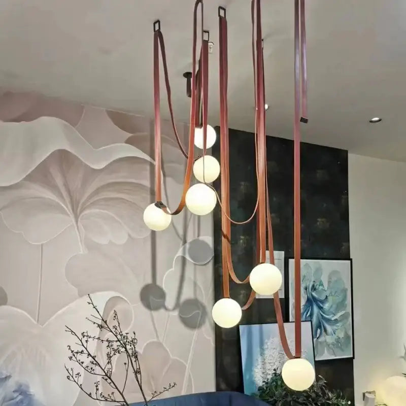 Modern copper decorbites glass ball pendant lamp with warm white spherical bulbs suspended by leather straps for dining room