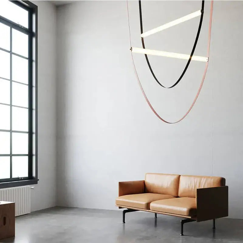 Tan leather sofa with dark wooden frame and black metal legs complementing modern decorbites leather belt chandelier