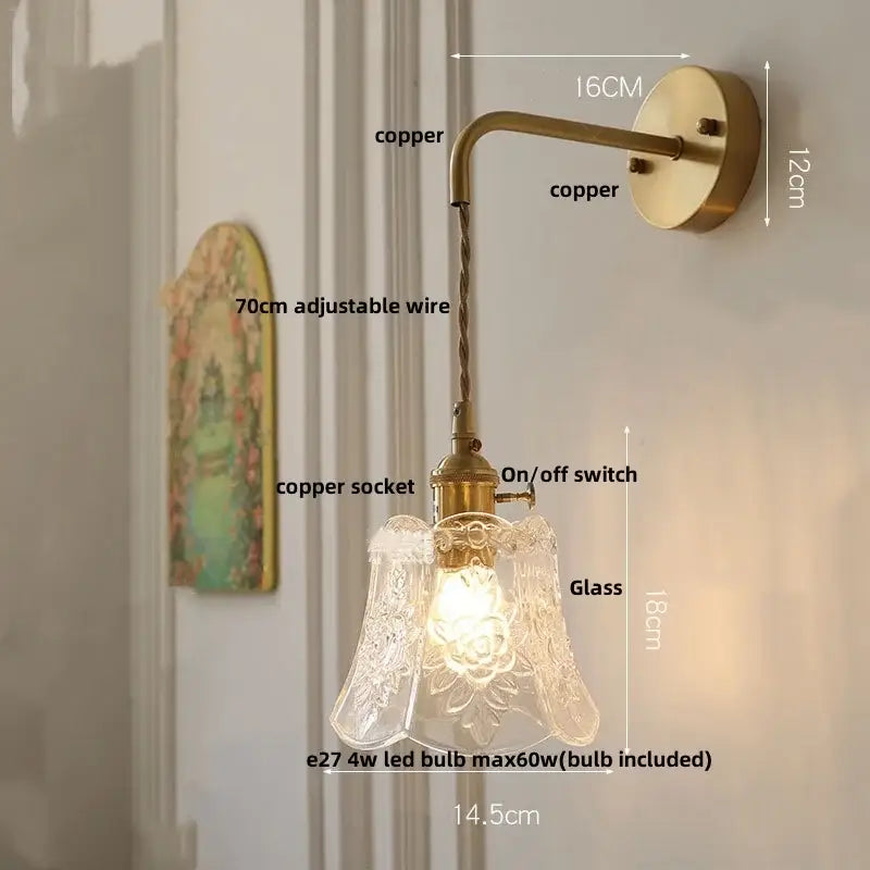 Antique brass-finished led wall light fixture with clear etched glass shade featuring floral patterns for bedroom use