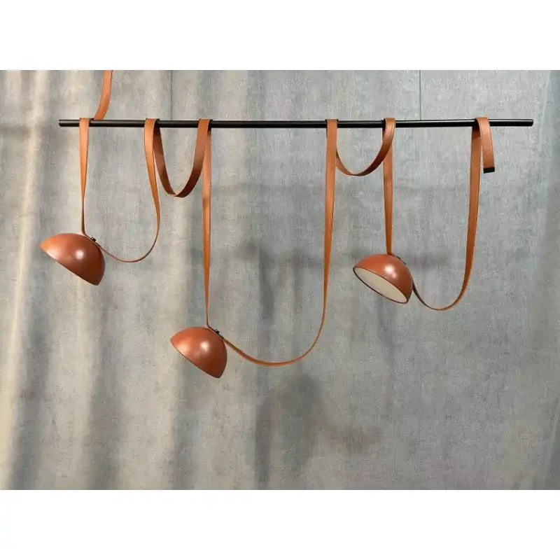 Modern copper led belt chandelier pendant light with sleek leather straps hanging from a black rod for living room decorbites led belt