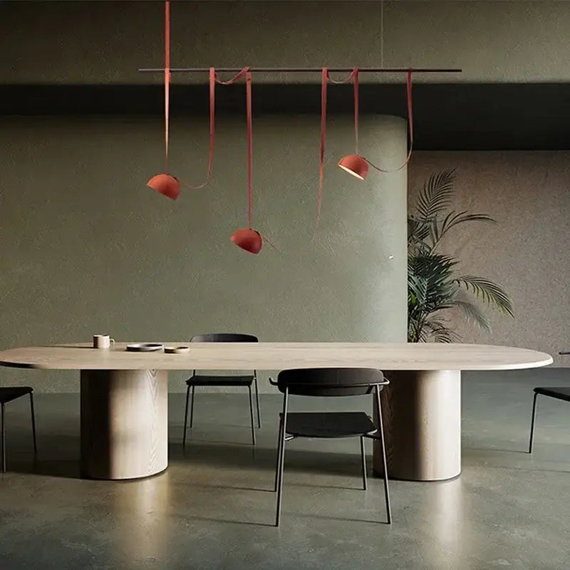 Modern minimalist dining table with light wood top and concrete legs under a modern copper led belt chandelier pendant light decorbites led belt