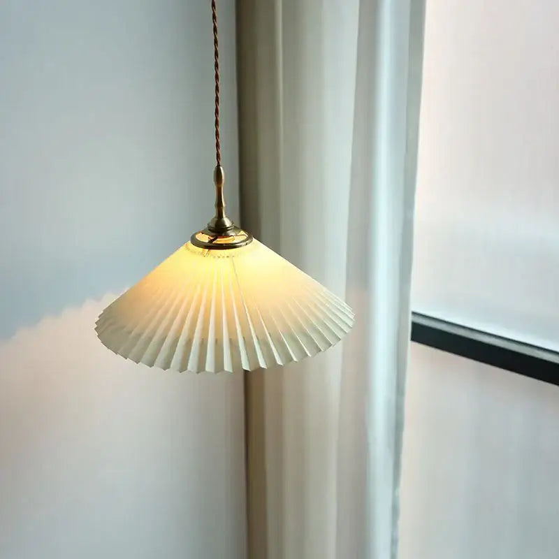A warm cream-colored pleated paper pendant lamp with brass fixture and twisted cord for decorbites copper led lighting