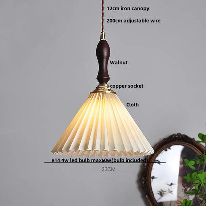 A warm-toned pleated fabric lampshade with dark walnut handle and brass accents on modern copper led pendant lamp