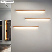 Three modern minimalist linear shaped wall sconces with warm copper finish for living room lighting
