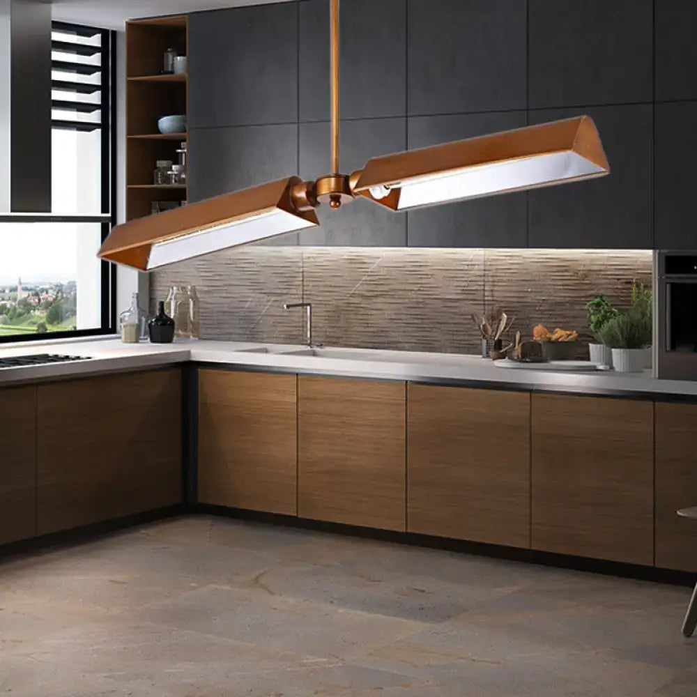Modern copper metal triangle pendant light with sleek angular design hanging above kitchen island counter