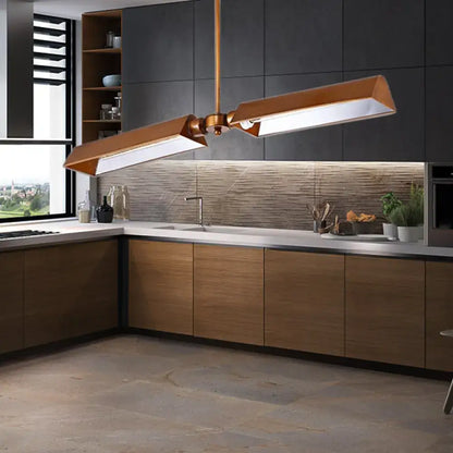 Modern copper metal triangle pendant light with sleek angular design hanging above kitchen island counter