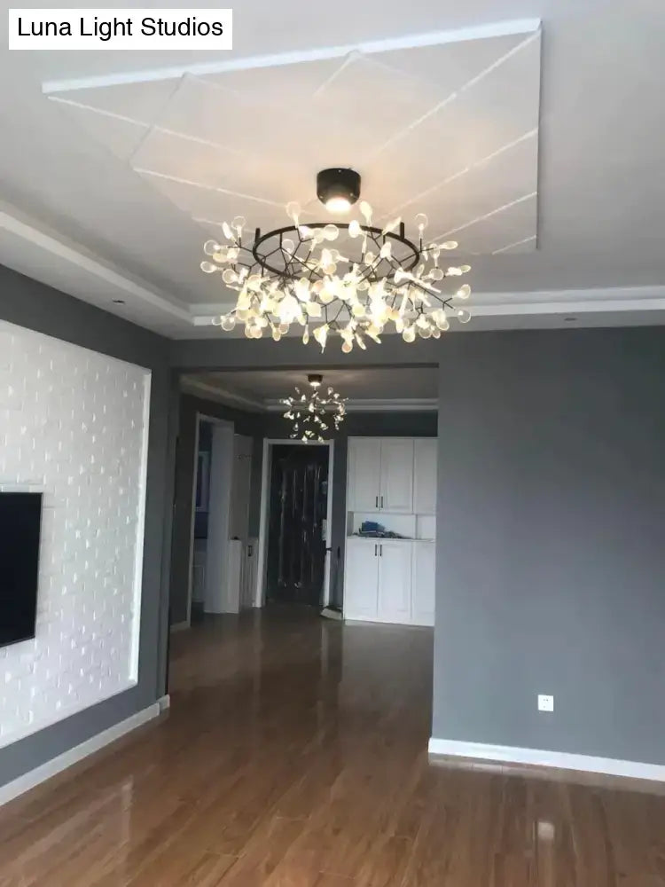 Modern pendant light with black metal frame and clear glass teardrops inspired by tree branch design for dining room use