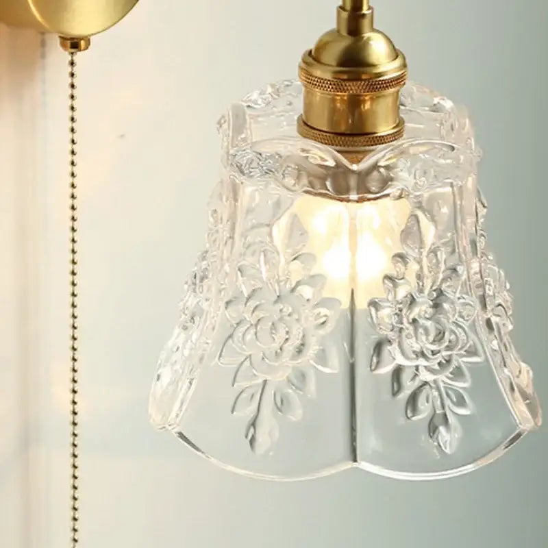Modern copper wall sconce with clear glass lampshade featuring intricate floral etching and brass-finished fixture decorbites clear glass