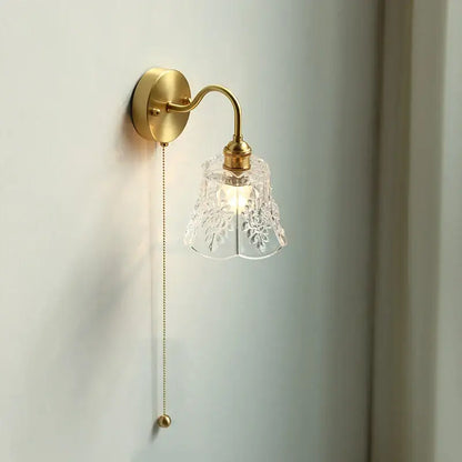 Modern copper wall sconce with a polished brass finish and decorbites clear glass etched shade for elegant bedroom lighting