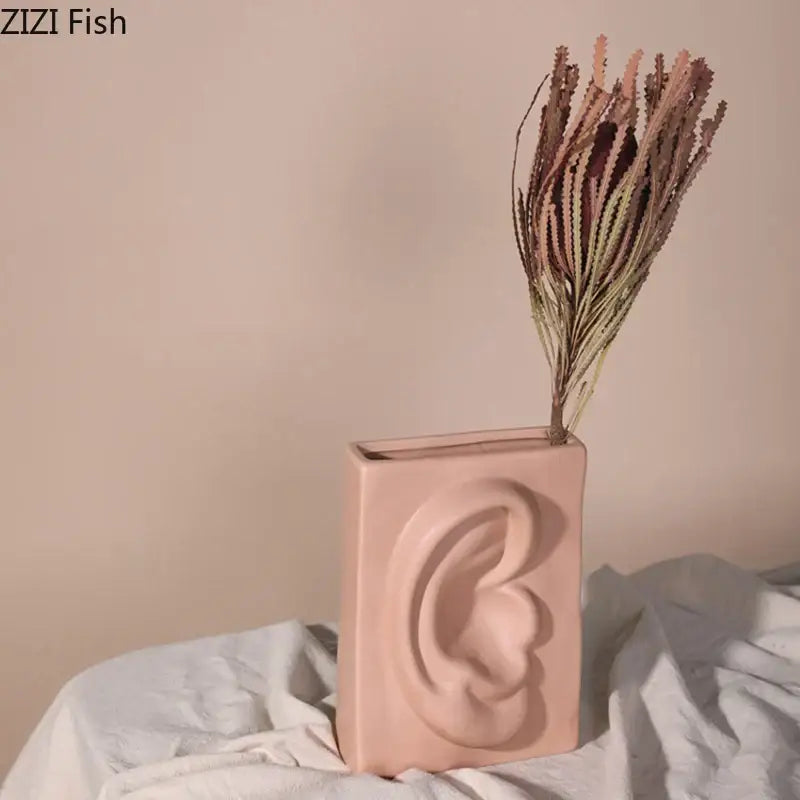 Modern coral pastel pink decorbites ceramic vase shaped like a human ear with dried foliage for living room decor