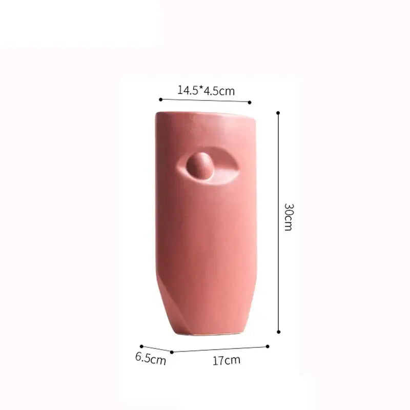 A sleek matte pink decorbites ceramic vase with minimalist embossed eye design for modern living room decor