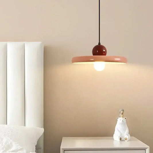 Modern coral and red flying saucer pendant light with metal construction and matte coral shade for dining rooms