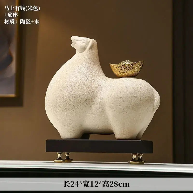 Modern cream and gold horse sculpture figurine decorbites with ceramic material and gold coin detail on dark wooden base