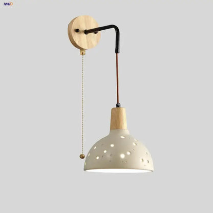 Modern cream ceramic and wood wall light with circular cutouts and pull chain switch for bedroom decorbites cement wood wall