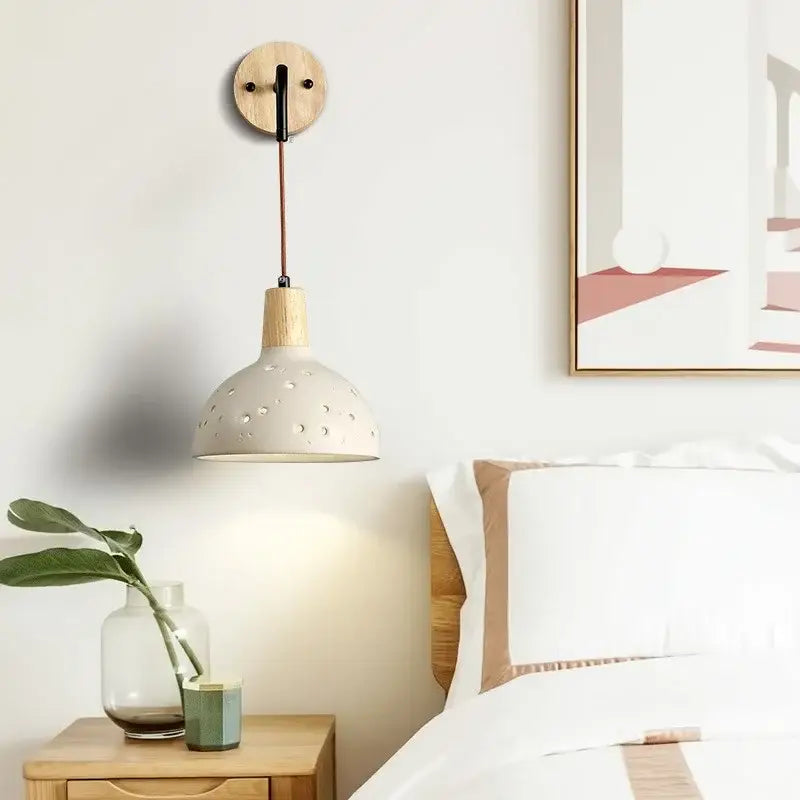 Modern cream ceramic and wood wall light with circular perforations and pull chain switch for bedroom decorbites cement wood wall