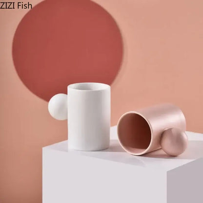 Two minimalist ceramic cups in white and rose gold with spherical handles from decorbites cotton candy saucer set