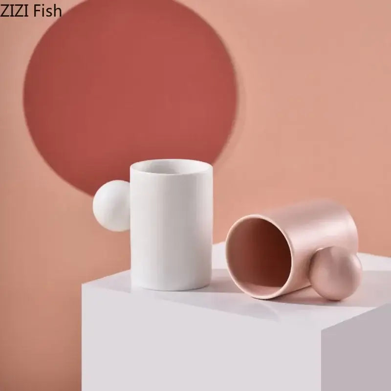 Two minimalist ceramic cups in white and rose gold with spherical handles from decorbites cotton candy saucer set