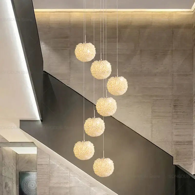 A modern cream crystal round room chandelier with five textured golden beige crystal spherical lights decorbites crystal round