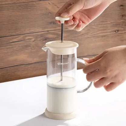 Modern cream glass french press coffee maker with plastic body and metal plunger serves as a hand foam mixer blender
